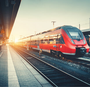 Image showing a modern train pulling into a station at sunrise