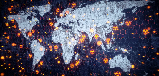 A stylised image of the world with the continents in white and the oceans in deep blue. Dotted around the land and oceans are nuclear hazard symbols representing nuclear explosions or tests