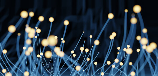 Against a black background in the foreground is a “forest” of pale blue nanowires with glowing tips 