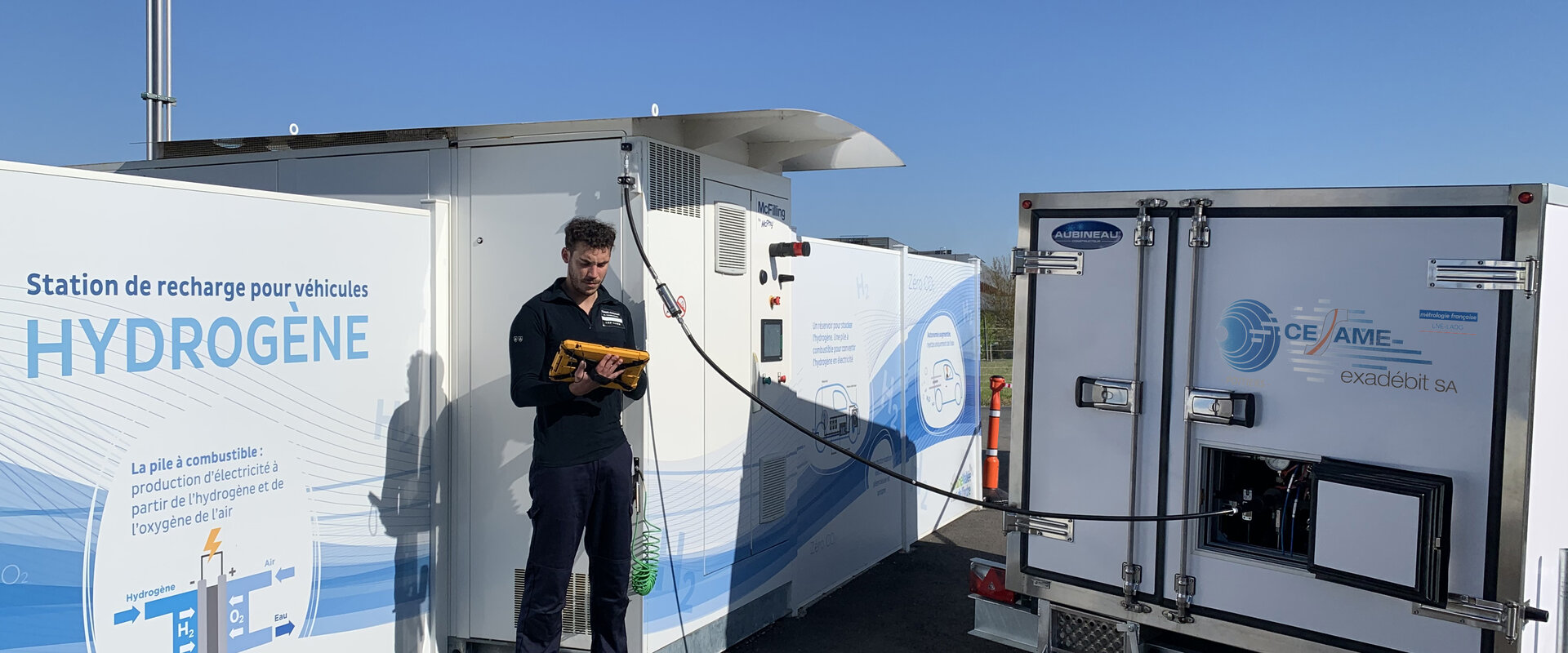 A technician monitors the Cesame-Exadebit mobile secondary measurement standard on a tablet computer while calibrating a hydrogen refuelling station