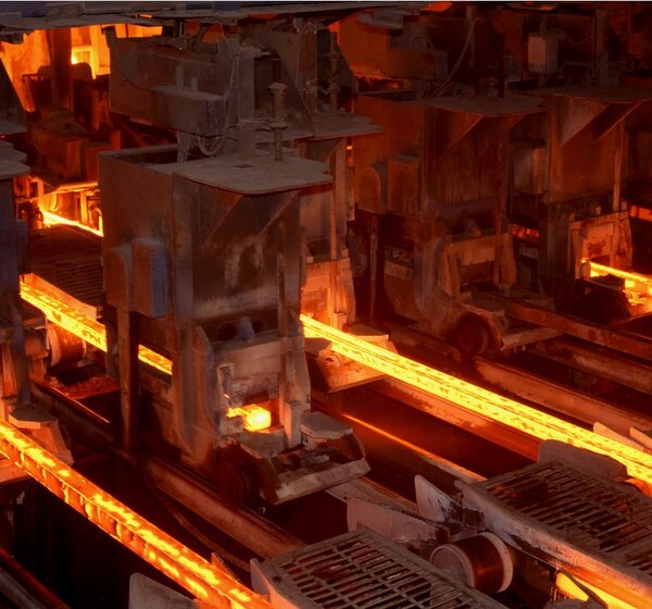 Image showing red-hot metal bars being made at an industrial plant