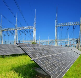 Solar energy panels in the background high voltage power substation