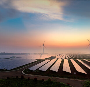 Image showing solar panels and wind turbines at sunrise